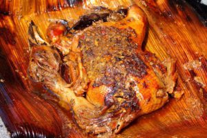 Menyantap kuliner bebek ataupun ayam betutu di Bali menjadi hal yang begitu gampang. Anda bisa menemukan begitu banyak warung makan atau restoran dengan sajian betutu khas Bali. Namun, kalau ingin mencicipi ayam atau betutu tradisional Bali yang tersaji secara eksklusif, pilihan terbaiknya adalah Mangku Gunung Lebah Ubud. Praktisi kuliner nusantara, mendiang Bondan Winarno begitu merekomendasikan tempat yang satu ini. Hanya saja, Anda akan menemukan kalau Mangku Gunung Lebah Ubud merupakan tempat yang tidak biasa. Tempat ini bukan merupakan warung, bukan pula sebuah restoran yang mewah. Mangku Gunung Lebah hanya berupa rumah warga biasa. Apa yang Membedakan Mangku Gunung Lebah Ubud dengan Tempat Lain? Mangku Gunung Lebah Ubud memang hanya berupa rumah biasa. Para pengunjung yang ingin menyantap betutu enak di sini, tidak bisa menyantapnya secara langsung di tempat. Tidak hanya itu. Anda juga tidak bisa serta merta datang untuk beli betutu di sini. Pemesanan harus dilakukan setidaknya sehari sebelumnya. Dengan cara pemesanan serta penjualan yang tidak biasa tersebut, tak heran kalau menyebut Mangku Gunung Lebah Ubud sebagai tempat yang eksklusif. Apalagi, kelezatan bebek serta ayam betutu yang ada di sini sudah begitu terkenal. Banyak wisatawan yang memilih sajian dari Pak Mangku sebagai pilihan oleh-oleh kuliner yang enak dari Bali. Cara Pembuatan Betutu Tradisional di Mangku Gunung Lebah Ubud Hal yang membuat ayam serta bebek betutu dari Pak Mangku Ubud begitu spesial bukanlah karena ketidaktersediaannya sarana untuk makan di tempat. Bukan pula karena pemesanan yang tidak bisa dilakukan secara langsung. Alasan utama dari begitu spesialnya betutu di sini adalah karena proses pembuatan secara tradisional. Bebek serta ayam betutu dari Mangku Gunung Lebah Ubud merupakan varian betutu gianyar. Untuk proses pembuatannya, butuh waktu yang begitu lama. Metode pemasakan yang dipakai merupakan cara slow cooking dengan cara dibakar menggunakan bara sekam padi dengan durasi kurang lebih 12 jam. Bebek atau ayam betutu di sini, biasanya akan dibungkus menggunakan daun pisang. Ayam atau bebek betutu yang didapatkan dari Mangku Gunung Lebah Ubud juga beda dibandingkan dengan betutu di tempat lain. Alasannya, karena betutu di sini merupakan varian betutu khas Gianyar yang gurih. Cara pembuatan yang spesial dan eksklusif juga membuat ayam serta bebek betutu di Mangku Gunung Lebah Ubud memiliki tekstur yang begitu lembut. Tidak akan sulit untuk memakan daging bebek atau ayamnya. Selain itu, rasa gurihnya juga akan begitu terasa di mulut. Untuk mencicipi kuliner eksklusif dari Bali ini, Anda bisa menelepon ke nomor (0361) 977808. Pemesanan harus dilakukan sebelum jam 3 siang waktu setempat. Mengenai harganya, untuk seekor ayam dipatok dengan banderol Rp95 ribu. Sementara itu, untuk bebek dihargai sebesar Rp110 ribu. Lokasi dari rumah Pak Mangku Gunung Lebah Ubud bisa Anda temukan di Banjar Penestaan Kaja, Sayan, Ubu.