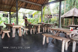 Menyantap kuliner bebek ataupun ayam betutu di Bali menjadi hal yang begitu gampang. Anda bisa menemukan begitu banyak warung makan atau restoran dengan sajian betutu khas Bali. Namun, kalau ingin mencicipi ayam atau betutu tradisional Bali yang tersaji secara eksklusif, pilihan terbaiknya adalah Mangku Gunung Lebah Ubud. Praktisi kuliner nusantara, mendiang Bondan Winarno begitu merekomendasikan tempat yang satu ini. Hanya saja, Anda akan menemukan kalau Mangku Gunung Lebah Ubud merupakan tempat yang tidak biasa. Tempat ini bukan merupakan warung, bukan pula sebuah restoran yang mewah. Mangku Gunung Lebah hanya berupa rumah warga biasa. Apa yang Membedakan Mangku Gunung Lebah Ubud dengan Tempat Lain? Mangku Gunung Lebah Ubud memang hanya berupa rumah biasa. Para pengunjung yang ingin menyantap betutu enak di sini, tidak bisa menyantapnya secara langsung di tempat. Tidak hanya itu. Anda juga tidak bisa serta merta datang untuk beli betutu di sini. Pemesanan harus dilakukan setidaknya sehari sebelumnya. Dengan cara pemesanan serta penjualan yang tidak biasa tersebut, tak heran kalau menyebut Mangku Gunung Lebah Ubud sebagai tempat yang eksklusif. Apalagi, kelezatan bebek serta ayam betutu yang ada di sini sudah begitu terkenal. Banyak wisatawan yang memilih sajian dari Pak Mangku sebagai pilihan oleh-oleh kuliner yang enak dari Bali. Cara Pembuatan Betutu Tradisional di Mangku Gunung Lebah Ubud Hal yang membuat ayam serta bebek betutu dari Pak Mangku Ubud begitu spesial bukanlah karena ketidaktersediaannya sarana untuk makan di tempat. Bukan pula karena pemesanan yang tidak bisa dilakukan secara langsung. Alasan utama dari begitu spesialnya betutu di sini adalah karena proses pembuatan secara tradisional. Bebek serta ayam betutu dari Mangku Gunung Lebah Ubud merupakan varian betutu gianyar. Untuk proses pembuatannya, butuh waktu yang begitu lama. Metode pemasakan yang dipakai merupakan cara slow cooking dengan cara dibakar menggunakan bara sekam padi dengan durasi kurang lebih 12 jam. Bebek atau ayam betutu di sini, biasanya akan dibungkus menggunakan daun pisang. Ayam atau bebek betutu yang didapatkan dari Mangku Gunung Lebah Ubud juga beda dibandingkan dengan betutu di tempat lain. Alasannya, karena betutu di sini merupakan varian betutu khas Gianyar yang gurih. Cara pembuatan yang spesial dan eksklusif juga membuat ayam serta bebek betutu di Mangku Gunung Lebah Ubud memiliki tekstur yang begitu lembut. Tidak akan sulit untuk memakan daging bebek atau ayamnya. Selain itu, rasa gurihnya juga akan begitu terasa di mulut. Untuk mencicipi kuliner eksklusif dari Bali ini, Anda bisa menelepon ke nomor (0361) 977808. Pemesanan harus dilakukan sebelum jam 3 siang waktu setempat. Mengenai harganya, untuk seekor ayam dipatok dengan banderol Rp95 ribu. Sementara itu, untuk bebek dihargai sebesar Rp110 ribu. Lokasi dari rumah Pak Mangku Gunung Lebah Ubud bisa Anda temukan di Banjar Penestaan Kaja, Sayan, Ubu.